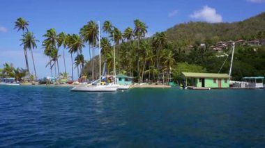 Marigot Körfezi, Saint Lucia. Karayip adası St. Lucia 'nın batı kıyısındaki Idyllic körfezi ve kasırga deliği. Üç tarafı sarp ve ormanlık tepelerle çevrili. Palmiye ağaçlarıyla kum tükürür