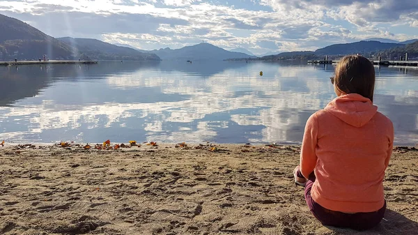 Woman Orange Hoodie Sitting Sandy Beach Woerthersee Austria Calm Lake — Foto Stock