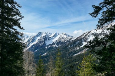A panoramic view from the top of Alpine peak in Austria. The whole area is shrouded in thick clouds. A few peaks popping out from the clouds. High mountain chains in the back. Carpet from the clouds