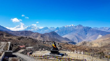A complex of Buddhist temples in Muktinath, along Annapurna Circuit Trek in Nepal. The temple is richly ornated with gold. In the back there is a high, snow capped Himalayan chain. Spirituality