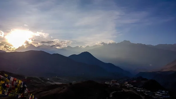 A Himalayan sunset, seen from a small village Muktinath, along Annapurna Circuit Trek in Nepal. The sun sets above high Himalayan peaks. Serenity and calmness.