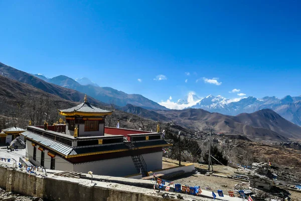 位于尼泊尔安纳普尔纳环路 Annapurna Circuit Trek 沿线穆克提纳 Muktinath 的佛教寺庙建筑群 这座庙宇装饰得富丽堂皇 在后面有一个高高的 积雪覆盖的喜马拉雅山链 — 图库照片