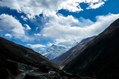 A small cottage located on steep slopes of Manang Valley, Annapurna Circus, Himalayas, Nepal, with Annapurna Chain and Gangapurna in the back. Dry and desolated landscape. Snow capped mountains