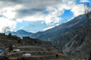 An ancient temple located on the way to Tilicho Base, Annapurna Circus Trek, Himalayas, Nepal, with the view on high snow capped mountain peaks. Dry and desolated landscape. Freedom and spirituality
