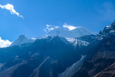 Harsh and golden colored slopes on the way to Tilicho Base Camp, Annapurna Circus Trek, Himalayas, Nepal, with the view on high snow capped mountain peaks. Dry and desolated landscape. Freedom