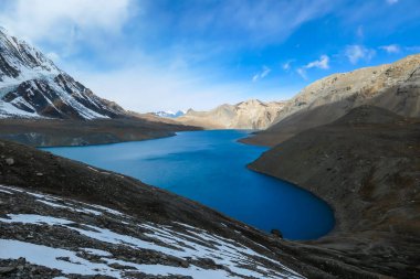 A panoramic view on turquoise colored Tilicho lake in Himalayas, Manang region in Nepal. The world's highest altitude lake (4949m). Snow capped mountains around. Calm surface of the lake. Serenity