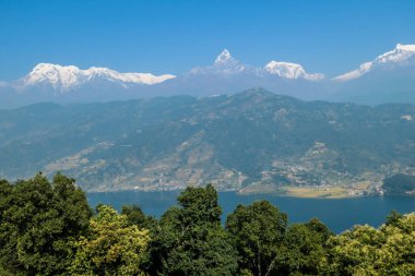 Panoramic view on Phewa Lake from World Peace Pagoda in Pokhara, Nepal. In the back there are high, snow capped Himalayan chains, with Mt Fishtail (Machhapuchhare) between them. Serenity and calmness