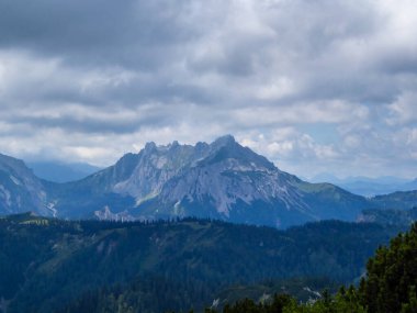 A panoramic view on the mountain chains in Hochschwab region in Austria. The slopes are steep and sharp. Endless chains of the mountains. Overcast and cloudy day.