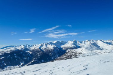 A panoramic view on snow capped Alps in Austria, seen from Katschberg Ski Resort in Austria.The slopes are covered with fresh, powder snow. Idyllic winter landscape. Sunny day
