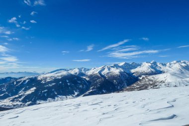 A panoramic view on snow capped Alps in Austria, seen from Katschberg Ski Resort in Austria.The slopes are covered with fresh, powder snow. Idyllic winter landscape. Sunny day