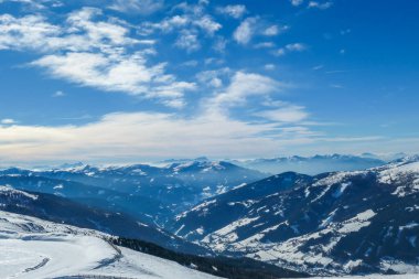 A panoramic view on snow capped Alps in Austria, seen from Katschberg Ski Resort in Austria.The slopes are covered with fresh, powder snow. Idyllic winter landscape. Sunny day