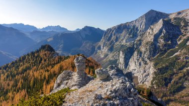 Panoramic view on mountains in Hochschwab region, Austrian Alps. The flora overgrowing slopes is golden. Autumn vibes in the mountains. Endless mountain chains shrouded in fog. Freedom and wilderness
