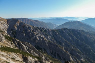 Panoramic view on mountains in Hochschwab region, Austrian Alps. The flora overgrowing slopes is golden. Autumn vibes in the mountains. Remote place, with no people. Freedom and wilderness