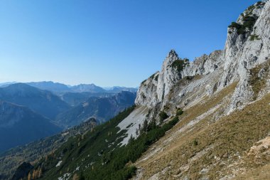 Panoramic view on mountains in Hochschwab region, Austrian Alps. The flora overgrowing slopes is golden. Autumn vibes in the mountains. Remote place, with no people. Freedom and wilderness