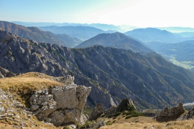 Panoramic view on mountains in Hochschwab region, Austrian Alps. The flora overgrowing slopes is golden. Autumn vibes in the mountains. Remote place, with no people. Freedom and wilderness