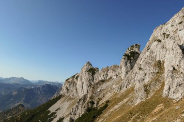 Panoramic view on mountains in Hochschwab region, Austrian Alps. The flora overgrowing slopes is golden. Autumn vibes in the mountains. Remote place, with no people. Freedom and wilderness