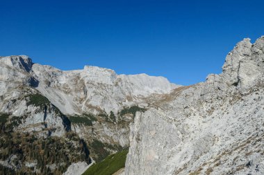 A view on a massive mountain wall in Alps in Hochschwab region, Austria. The slopes are really steep and dangerous to climb. Rocky landscape. Remote place, with no people. Freedom and wilderness
