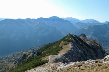 Panoramic view on Hochschwab region, Austrian Alps. Steep mountain ridge. The flora overgrowing slopes is golden. Autumn vibes in the mountains. Remote place, with no people. Freedom and wilderness