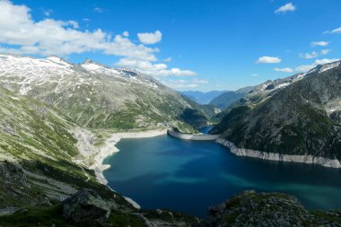 Dam in Austrian Alps. The artificial lake stretches over a vast territory, shining with navy blue color. The dam is surrounded by high mountains. In the back there is a glacier. Controlling the nature clipart