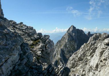 A panoramic view on Alpine slopes in Austria. There are sharp ans steep mountains and high peaks around. The Alpine slopes are almost barren, just moss overgrowing the slopes. Serenity and freedom.