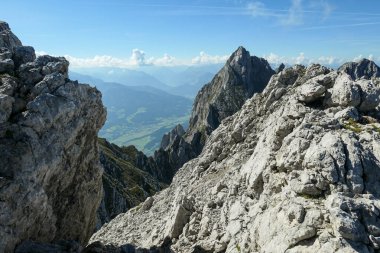 A panoramic view on Alpine slopes in Austria. There are sharp ans steep mountains and high peaks around. The Alpine slopes are almost barren, just moss overgrowing the slopes. Serenity and freedom.