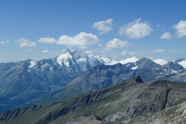 Panoramic view from top of Hohe Sonnblick in Austrian Alps on Grossglockner. The whole area is very steep and dangerous, with many lose stones. Many mountain chains in the back. Sunny day. Expedition