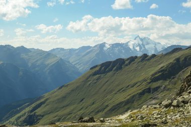 Panoramic view from Hohe Sonnblick in Austrian Alps on Grossglockner. The whole area is very steep and dangerous, with many lose stones. Green, steep meadows in front. Sunny day. Expedition