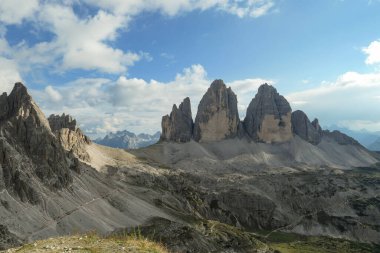 A panoramic capture of the famous Tre Cime di Lavaredo (Drei Zinnen) and surrounding mountains in Italian Dolomites. The mountains are surrounded by thick clouds. A lot of landslides. Serenity