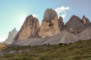 A capture of the Tre Cime di Lavaredo (Drei Zinnen) in Italian Dolomites. The mountains are highlighted by the sunbeams. There is a lot of landslides. Natural wonder. Discovery and adventure