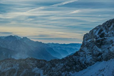 Cloudy and misty morning in Alps, Nassfeld, Austria. Delicate snow fall. Mountain slopes covered with snow. Sharp edges of the Alps. Softly colored sky. a new day begins.
