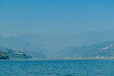 The Phewa Lake while hiking to the Peace Pagoda, Pokhara, Nepal. Behind the lake Annapurna Chain, with holly Mt. Fishtail.  Beautiful mountain range, clear lake surface.