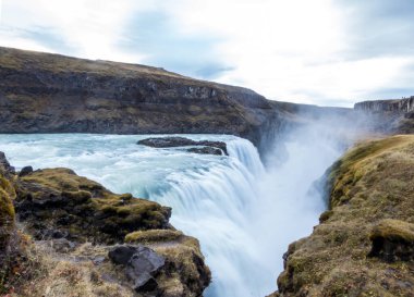 A mighty waterfall, falling into a gorge, spreading on a vast distance. Bottom of the waterfall is not visible. Gullfoss waterfall located in the canyon of the Hvita river in southwest Iceland