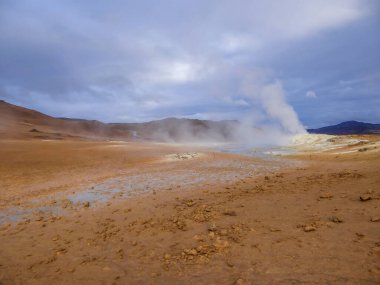 Smoking pool, filled with sulfur. Thick and dense smoke surrounding the whole area. Geothermal activity region in Iceland, Hverir. Place where you feel connected to the power of the planet.