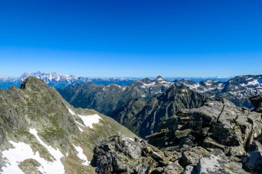 Massive mountain range of Schladming Alps, Austria. The slopes of Alps are steep, partially overgrown with green bushes. Dangerous mountain climbing.Clear and beautiful day. Endless mountain ranges,