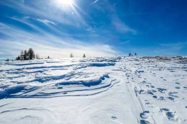 Sunny winter day in the austrian alps in the ski resort of  Bad Kleinkirchheim, Austria. The snow shows a nice reflection. Winter sports in Alpine winter wonderland