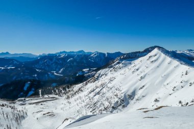 A panorama of a snow caped mountains Alps in Goldeck, Austria. Crispy and frosty morning. The ground is completely covered with snow. Endless mountain chains in the back. Serenity and solitude