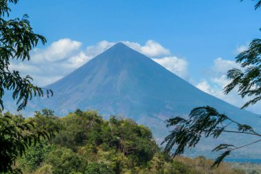 A distant view on Volcano Inierie, Bajawa, Indonesia. The pyramid like mountain towers above the landline. There are no other high volcanos around. The upper slopes are bare without any vegetation.