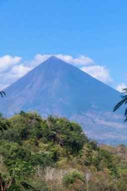 A distant view on Volcano Inierie, Bajawa, Indonesia. The pyramid like mountain towers above the landline. There are no other high volcanos around. The upper slopes are bare without any vegetation.