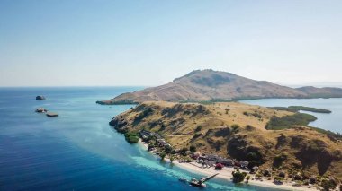 A drone shot of two bigger paradise islands in Komodo National Park, Flores, Indonesia. The islands have scarcely any trees and bushes. Dry land. Idyllic white sand beaches. Island hoping