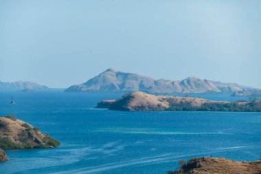 Idyllic island formation seen from Komodo Island in Indonesia. Discovering new places. Calm sea gently washes the shores of the islands. Volcanic islands with barely any plants.