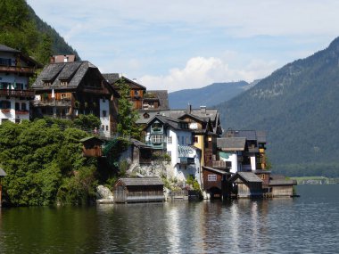 Small village located by the lake in Hallstatt, Austria. The houses have many different colors. Alpine village. Idyllic landscape. Coexistence of human and nature. High mountains rising from the lake
