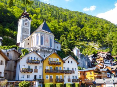 Small village located by the lake in Hallstatt, Austria. The houses have many different colors. Alpine village. Idyllic landscape. Coexistence of human and nature. High mountains rising from the lake