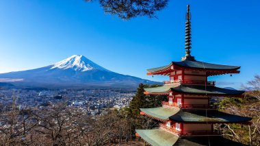 View on Chureito Pagoda and mountain of the mountains Mt Fuji, Japan, captured on a clear, sunny day in winter. Top of the volcano covered with snow. Trees aren't blossoming yet. Postcard from Japan.