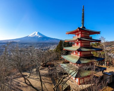 View on Chureito Pagoda and mountain of the mountains Mt Fuji, Japan, captured on a clear, sunny day in winter. Top of the volcano covered with snow. Trees aren't blossoming yet. Postcard from Japan.