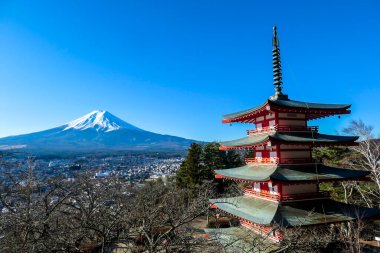 View on Chureito Pagoda and mountain of the mountains Mt Fuji, Japan, captured on a clear, sunny day in winter. Top of the volcano covered with snow. Trees aren't blossoming yet. Postcard from Japan.
