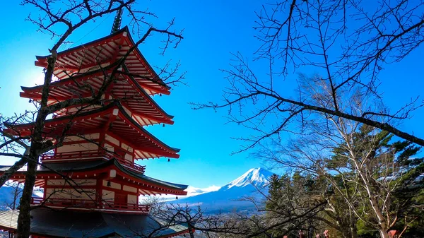 冬の晴れた日に撮影された 日本の富士山の中央塔と山の景色 火山の頂上は雪で覆われていた 木はまだ咲いていません 日本からのはがき — ストック写真