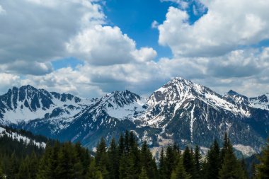A view on a massive mountain range, partially covered with snow, seen from Himmeleck, Austria. Dangerous mountain climbing. Spring slowly coming to high altitudes. Awakening after hibernation