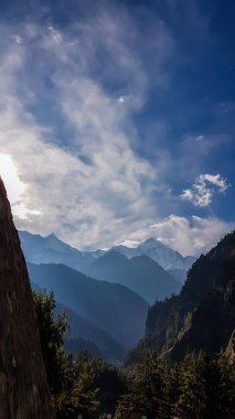 An endless view on Himalayan chain from Chame, Annapurna Circuit Trek in Nepal. The mountains are shrouded in fog. A bit of overcast. Steep slopes along the pathway. Serenity and peace of mind.
