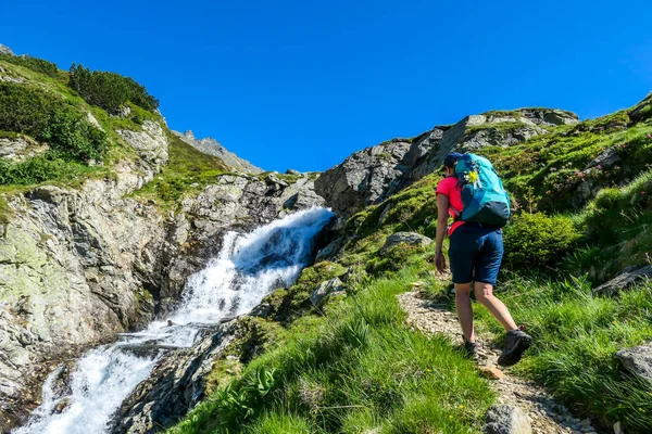 Young Woman Big Backpack Hikes Steep Pathway Mountain Stream Water — Stock fotografie