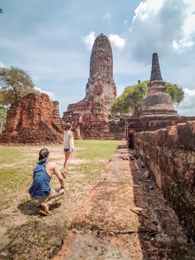 A couple admiring buildings in Ayutthaya Historical Park, Thailand. UNESCO list. Ruins of an ancient city, built of bricks. beautiful and clear day.  